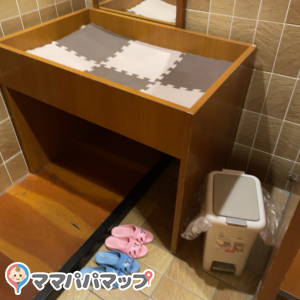 女性トイレにオムツ替え台、ゴミ箱、子供用サンダルあります。