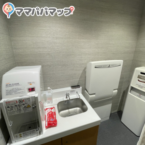 Purified hot water server for milk formula, changing table and chair to sit for breastfeeding.